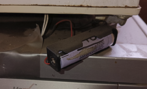 An 18650 and holder, sitting between two freezers and providing power to two Aqara sensors