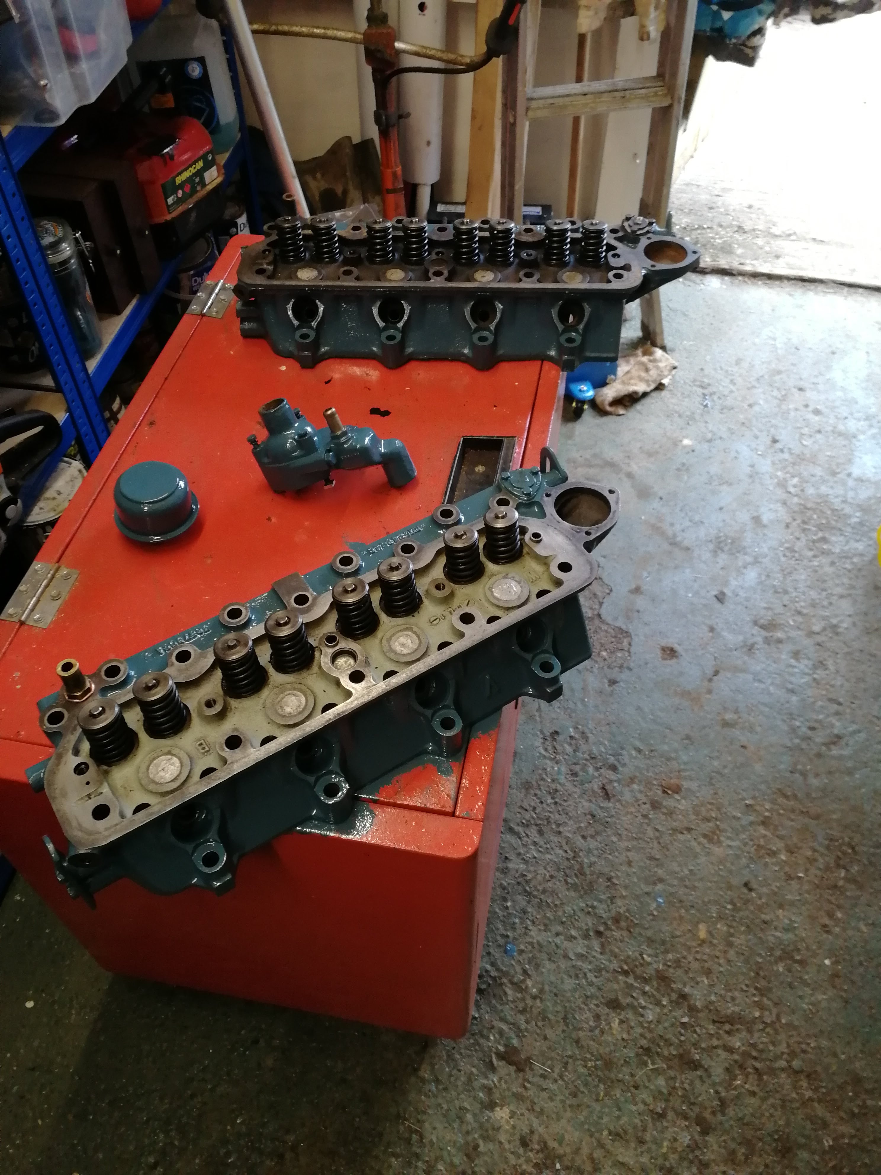 Old and new heads, together with thermostat housing and oil filler cap